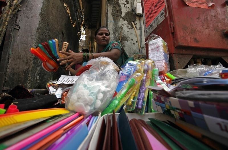 Tairabi Pathan, 40, who took a loan of rupees 10,000 ($220) from a micro finance company to start her own business, arranges her goods for sale at the side of a road in a slum area in Mumbai October 26, 2010. India's microfinance industry, which surged to prominence when George Soros-backed SKS Microfinance raised $358 million in an IPO, faces a regulatory clampdown that could erode profits and hurt growth. Reports of dozens of suicides by poor borrowers in the southern state of Andhra Pradesh, the hub of India's microfinance sector, prompted the state to enact an rules against aggressive recovery practices by lenders who make loans that average about $150 to poor customers at interest rates that can top 30 percent. Picture taken October 26, 2010. To match analysis INDIA-MICROFINANCE/ REUTERS/Danish Siddiqui (INDIA - Tags: SOCIETY BUSINESS) - GM1E6AS11VZ01
