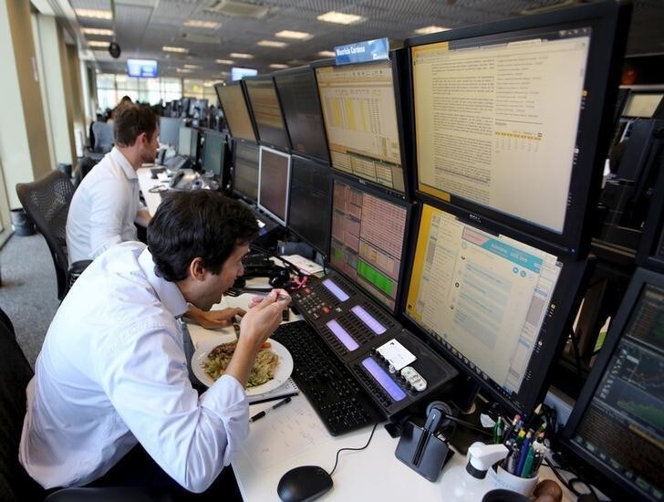 A trader eats lunch at his desk at a brokerage in Sao Paulo, Brazil. REUTERS/Paulo Whitaker