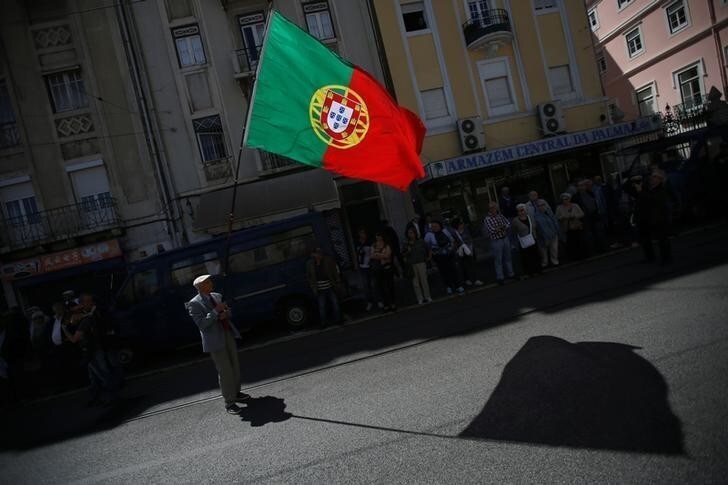 A demonstrator holds a Portuguese flag as he waits for the start of a May Day demonstration in Lisbon, Portugal May 1, 2017. REUTERS/Rafael Marchante