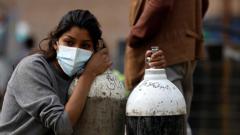 Lady clutches to two tanks of oxygen.