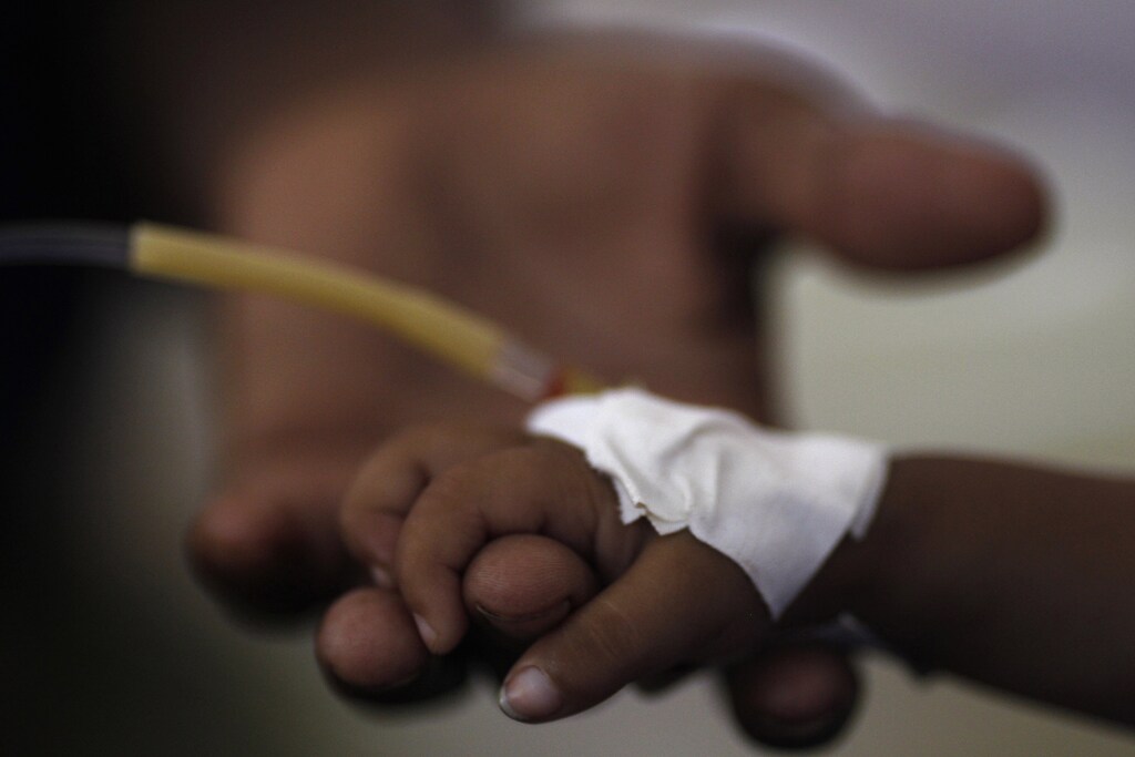A sick Pakistani baby, who is a victim of the flood, holds the finger of her mother after being given first aid at a hospital in Pakistan's Muzaffargarh district of Punjab province September 4, 2010. The flooding has destroyed cropland and livestock and displaced millions of people, causing damage the government has estimated at $43 billion, or almost one quarter of the South Asian nation's 2009 GDP. REUTERS/Damir Sagolj (PAKISTAN - Tags: DISASTER ENVIRONMENT IMAGES OF THE DAY) - GM1E6941T6301