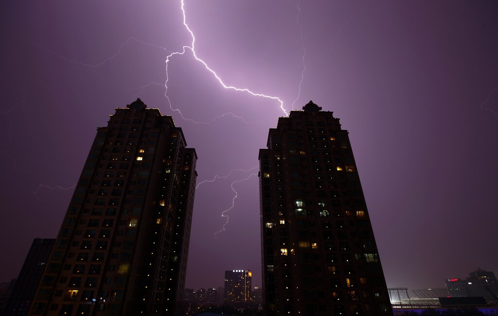 Lightning is seen above buildings in Beijing, July 31, 2013. Picture taken July 31, 2013. REUTERS/Petar Kujundzic (CHINA - Tags: ENVIRONMENT TPX IMAGES OF THE DAY) - GM1E9810KR701