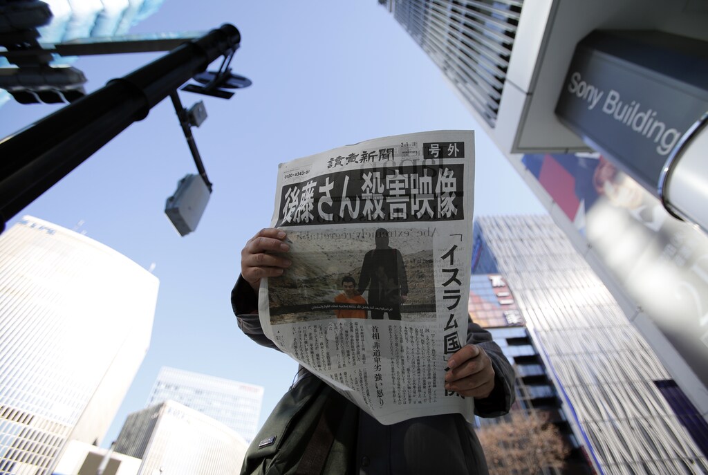 A man reads an extra edition of a newspapers, which reported that Islamic State militants said they had beheaded Japanese journalist Kenji Goto, in Tokyo's Ginza district February 1, 2015. Islamic State militants said on Saturday they had beheaded a second Japanese hostage, journalist Kenji Goto, after the failure of international efforts to secure his release through a prisoner swap. REUTERS/Toru Hanai (JAPAN - Tags: POLITICS CRIME LAW CIVIL UNREST TPX IMAGES OF THE DAY) - GM1EB210RGZ01