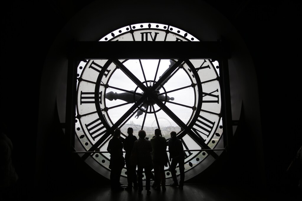 Visitors at the Musee d'Orsay are seen in silhouette as they look behind a giant clock face at the former Orsay railway station, in Paris, France July 28, 2015. The national museum of the Musee d'Orsay opened in December 1986 and it displays collections of art from the period 1848 to 1914. France has been the world's most visited country since the 1980's, welcoming 84 million tourists last year. REUTERS/Stephane Mahe - PM1EB7S1DSU01
