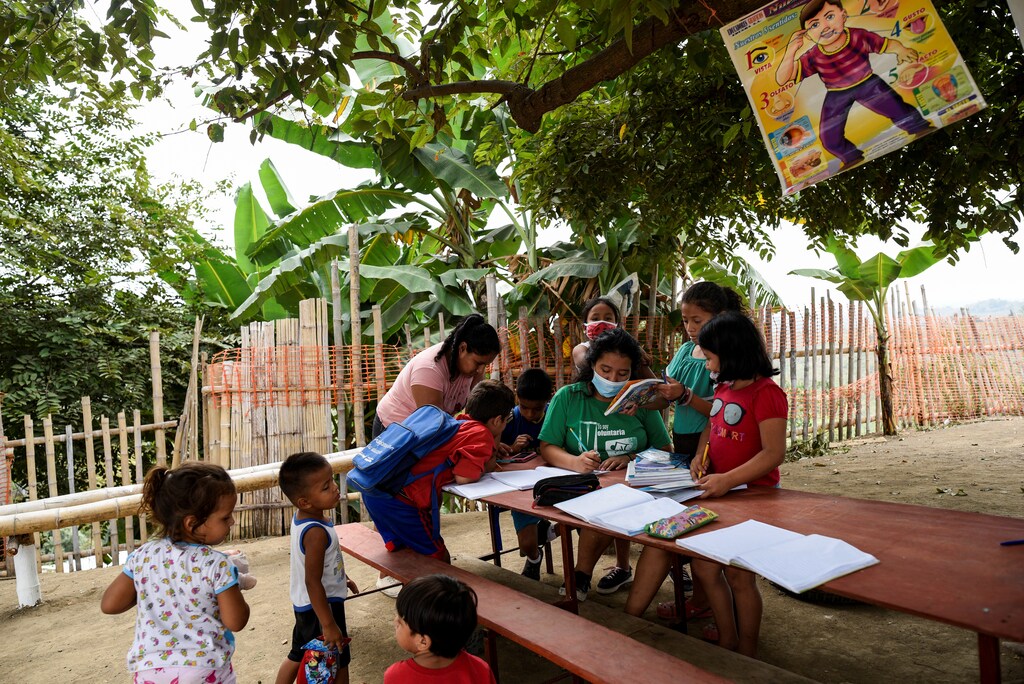 Denisse Toala (C), a 16-year-old student, teaches children in an improvised school she has set up under a tree since they have been unable to attend virtual classes in the low-income neighbourhood Realidad de Dios, during the outbreak of the coronavirus disease (COVID-19), in Guayaquil, Ecuador July 2, 2020. Picture taken July 2, 2020. REUTERS/Santiago Arcos - RC26TH9RALAO