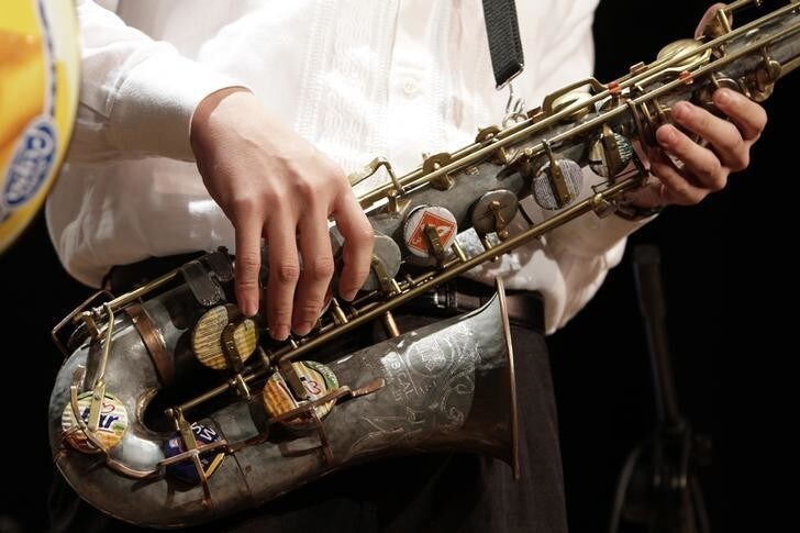 A member of the Orchestra of Recycled Instruments of Cateura holds his saxophone refurbished from recycled materials during a concert in Asuncion, June 22, 2013. The orchestra is the brainchild of its director Favio Chavez, who wanted to help the children of garbage pickers at the local landfill, and the instruments are made from salvaged materials by craftsman Nicolas Gomez. The orchestra now involves 30 schoolchildren who have toured countries in Latin America, North America and Europe to play music ranging from Beethoven and Mozart to The Beatles and Paraguayan folk songs. Picture taken June 22, 2013. REUTERS/Jorge Adorno (PARAGUAY - Tags: SOCIETY)