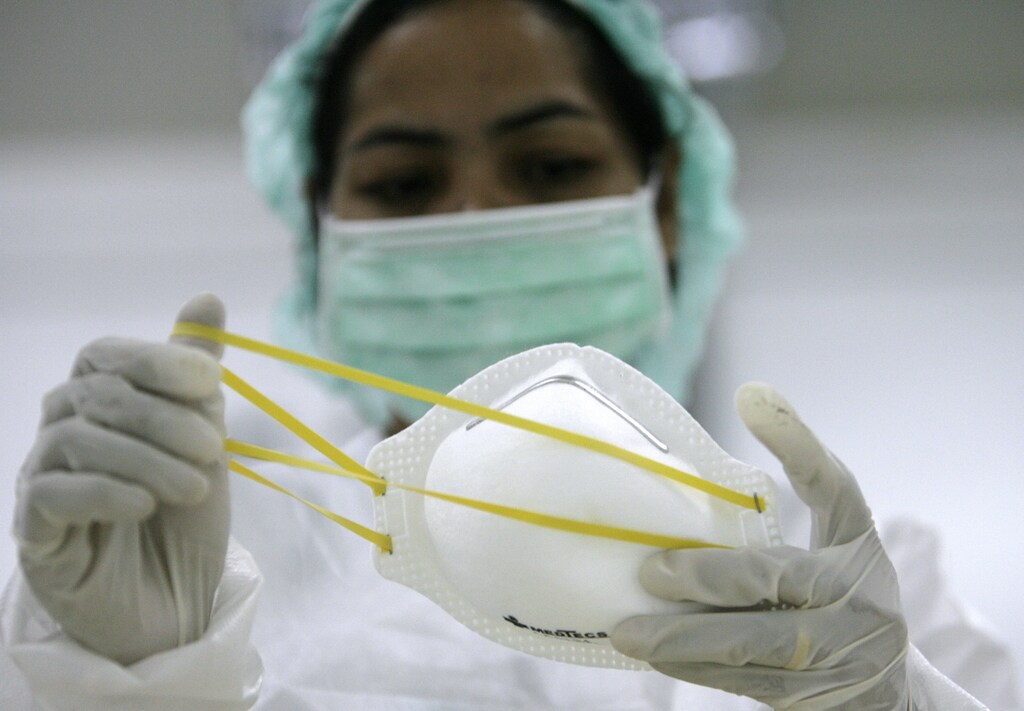 A worker inspect a finished product of a N95 face masks inside a Medtecs warehouse in Bataan province, north of Manila April 30, 2009. Medtecs, a plant in the Philippines producing face masks and isolation gowns has increased production by three times as demand for protected equipment grows due to swine flu outbreak. REUTERS/Romeo Ranoco (PHILIPPINES HEALTH SOCIETY) - GM1E54U182K01