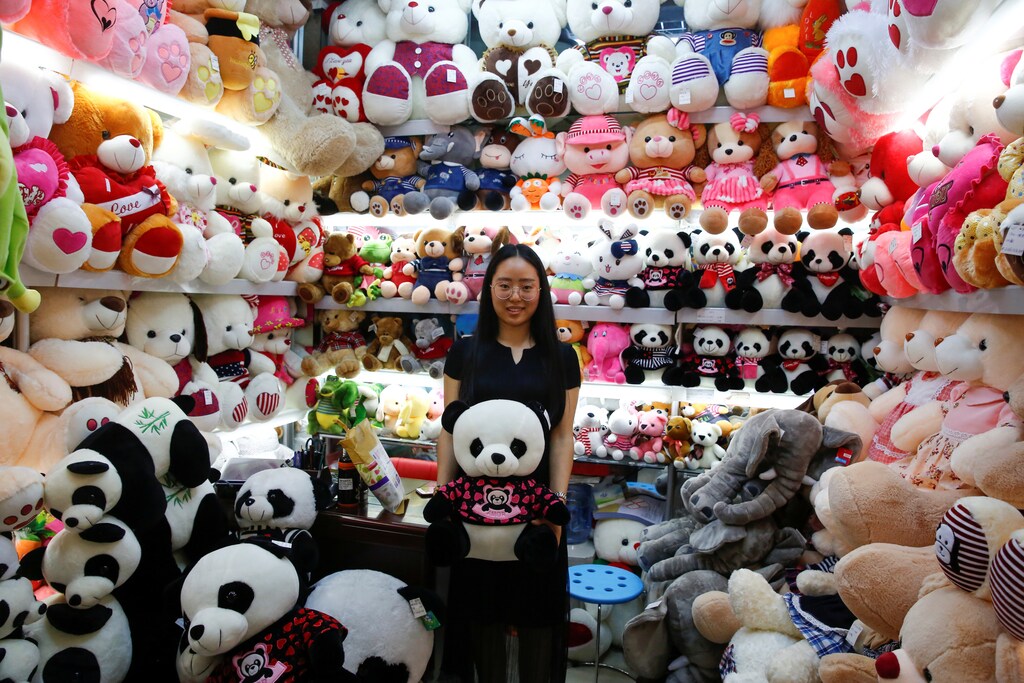 A staff member holds a Panda soft toy as she poses for a picture in a stall at the Yiwu Wholesale Market in Yiwu, Zhejiang province, China, April 28, 2017. Picture taken April 28, 2017. REUTERS/Thomas Peter - RTS14F4T