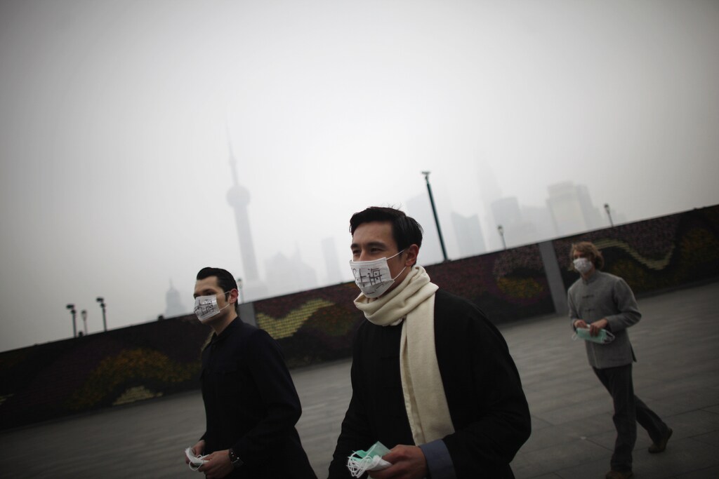 A group of expatriates walk along the Bund as they distribute face masks to pedestrians to raise awareness of air pollution in downtown Shanghai January 24, 2013. According to the U.S. consulate air quality readings, which measure PM2.5 particulates Shanghai's air quality was "very unhealthy" on Thursday. REUTERS/Carlos Barria