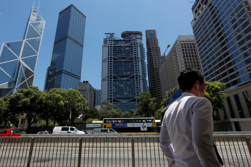 A man walks in front of the (L-R) Bank of China Tower, Cheung Kong Center, HSBC bank and Standard Chartered bank at the financial central district in Hong Kong, China June 24, 2016. REUTERS/Bobby Yip - RTX2HX4H