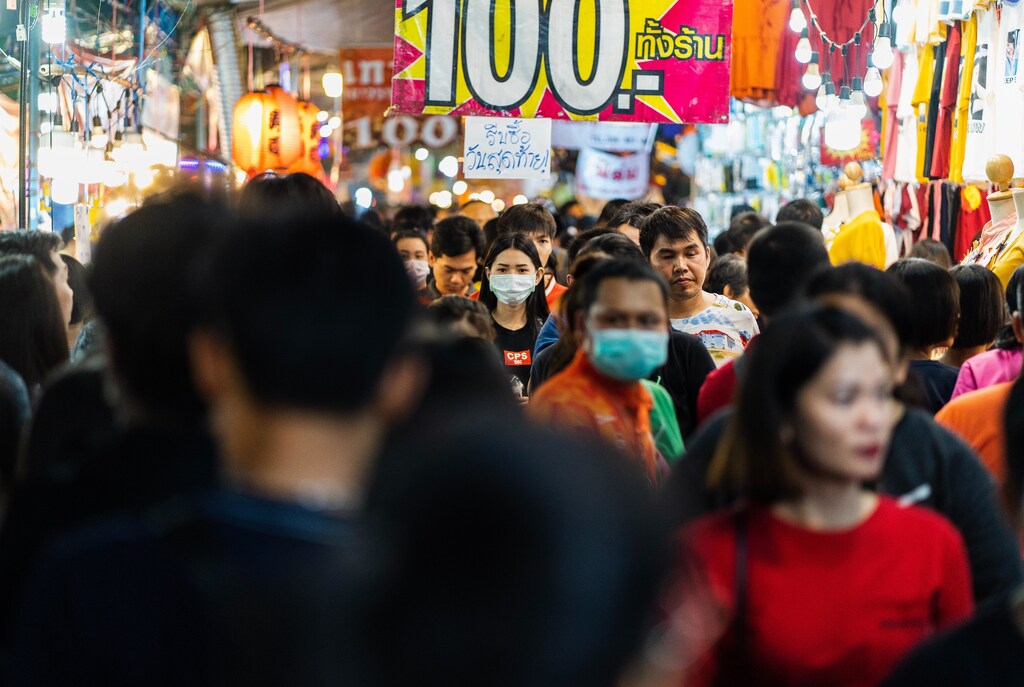 People wear masks in a busy Thai shopping street, as COVID-19 cases rise in parts of the world.