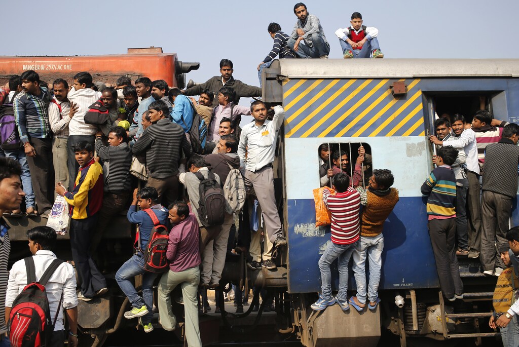 Passengers board an overcrowded train near a railway station at Loni town in the northern state of Uttar Pradesh, India, February 24, 2016. India's federal-run railways will have to depend on more government support and borrowing to fix their finances in its budget on Thursday, with New Delhi reluctant to unveil steep fare hikes ahead of key state elections, officials said. REUTERS/Anindito Mukherjee - D1AESOWINXAA