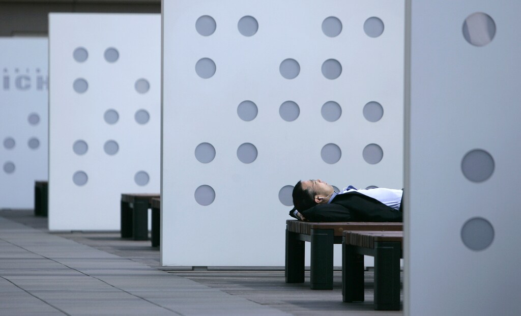 A businessman takes a nap on a bench in Tokyo June 8, 2007. Japan's weather is expected to stay mostly average to slightly warmer in the week from Saturday, the official weather forecaster said on Friday. REUTERS/Toru Hanai (JAPAN) - RTR1QKX7