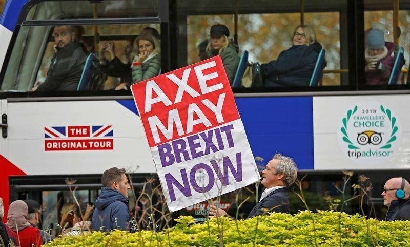 A pro-Brexit campaigner holds a placard as a tourist bus passes by in Westminster London, Britain, November 16, 2018. REUTERS/Peter Nicholls - RC1B71EFE970
