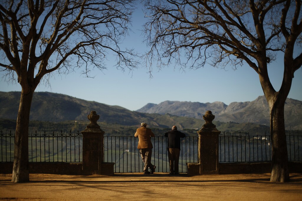 Men look at scenery from a balcony in a park in Ronda, near the southern Spanish city of Malaga, January 13, 2011. Spain's economy is capable of growing by 2-2.5 percent annually from 2011 to 2015, but the country must forge ahead on reforms with or without a political consensus, Prime Minister Jose Luis Rodriguez Zapatero said on Tuesday. Among austerity plans announced are a reform of the country's pension system which would raise the retirement age from 65 to 67. REUTERS/Jon Nazca (SPAIN - Tags: EMPLOYMENT BUSINESS POLITICS SOCIETY) - GM1E71D1PNJ01