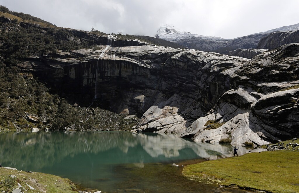 A boy fishes for trout at lake Rajupaquinan at Huascaran natural reserve in Ancash November 29, 2014. Peru has more tropical glaciers than any other nation but rising temperatures linked to global warming have helped shrink the ice masses by up to 40 percent, filling existing lakes to the brim and spawning hundreds of new ones. In Lima, nearly 200 governments are meeting this week to thrash out a rough draft of a deal to cut carbon emissions in a bid to ward off more warming. The deal is due to be agreed in Paris in late 2015. Picture taken November 29. To match story CLIMATECHANGE-LIMA/GLACIERS REUTERS/ Mariana Bazo (PERU - Tags: ENVIRONMENT) - RTR4HNMW