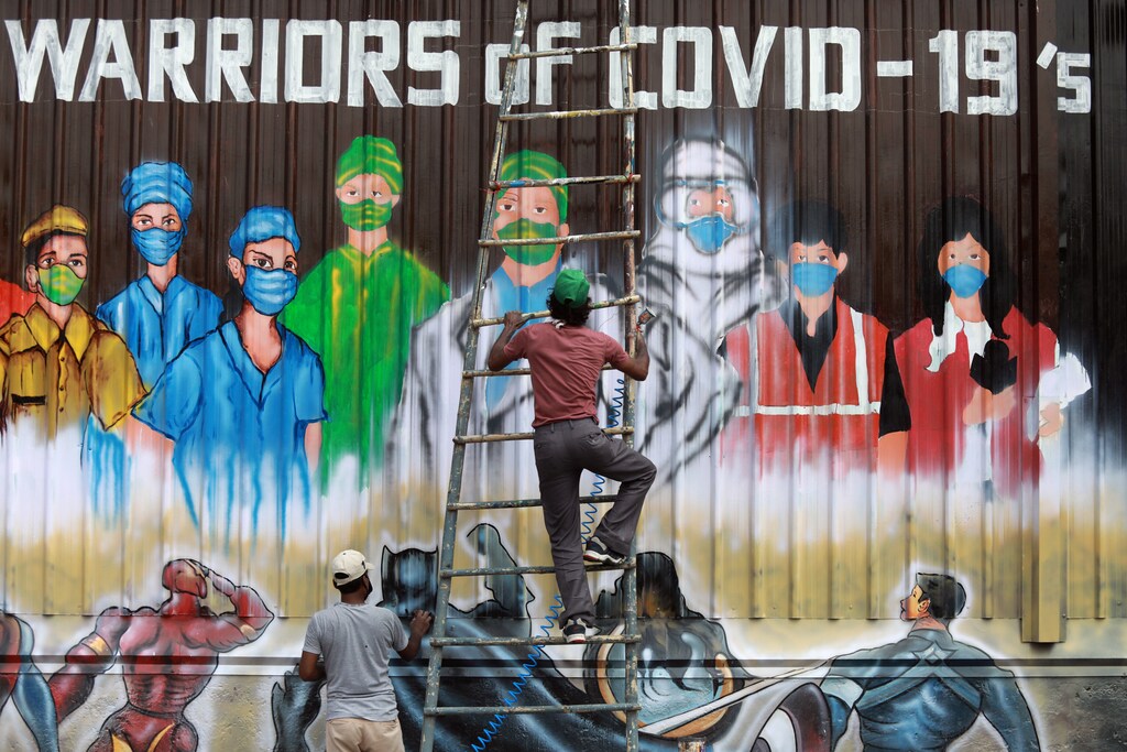 A man gets off a ladder as he completes a mural paying tribute to 'COVID-19 warriors' as India eases lockdown restrictions that were imposed to slow the spread of the coronavirus disease (COVID-19), in New Delhi, India, June 8, 2020. REUTERS/Anushree Fadnavis TPX IMAGES OF THE DAY - RC2X4H9288EP