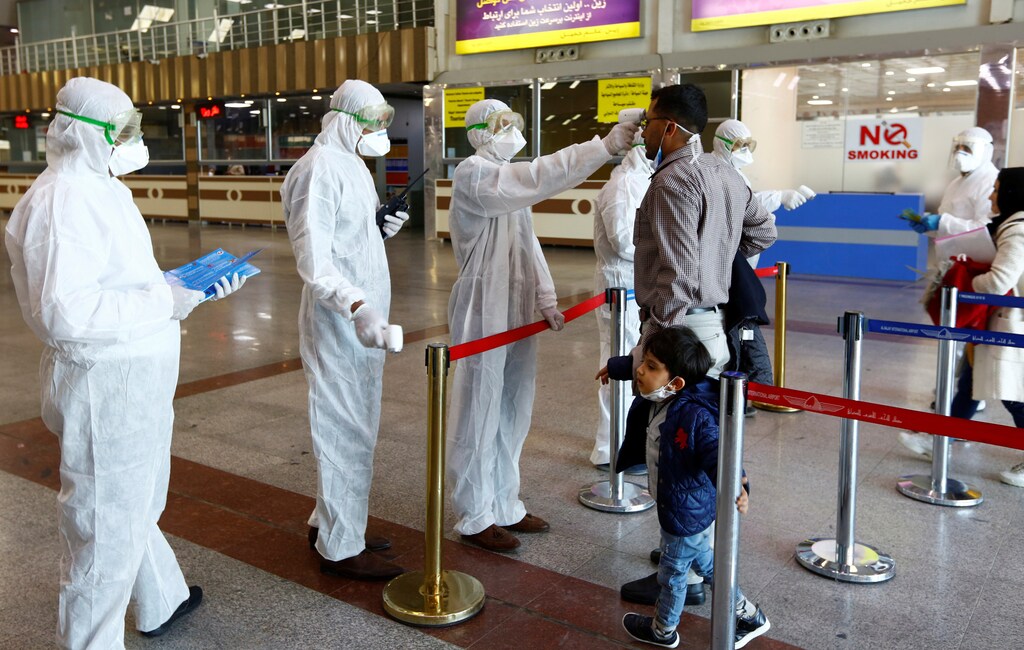 Iraqi medical staff check passengers' temperature, amid coronavirus outbreak, upon their arrival from Iran, at Najaf airport, Iraq March 5, 2020. REUTERS/Alaa al-Marjani - RC2QDF9IT3JA
