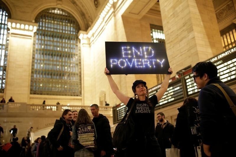 A female demonstrators holds an "End Poverty" light up sign during Non-March for Disabled Women hosted by Rise and Resist with help from the Women's March NYC in Grand Central Station in the Manhattan borough of New York City, New York, U.S., January 19, 2019. REUTERS/ Jose Alvarado Jr. - RC18D09D4F00