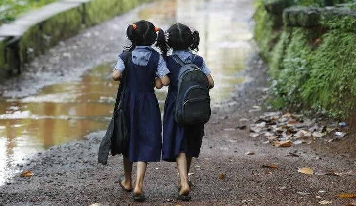 Seven year old twins Shahana (R) and Shahala (L) walk to their school in Kodinji village in the southern Indian city of Kerala July 28, 2009. Kodinji, with around 2,000 families, has at least 204 pairs of twins, according to survey by Twins and Kins Association (TAKA), a voluntary organisation. Picture taken July 28, 2009. REUTERS/Arko Datta (INDIA EDUCATION SOCIETY)