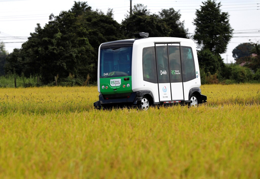 Robot Shuttle, a driver-less, self driving bus, using software developed by Japan's internet commerce and mobile games provider DeNA Co., drives past between rice stalk during an experimental trial with a self-driving bus in a community in Nishikata town, Tochigi Prefecture, Japan September 8, 2017. Picture taken September 8, 2017. REUTERS/Issei Kato - RC1B9E71DC30