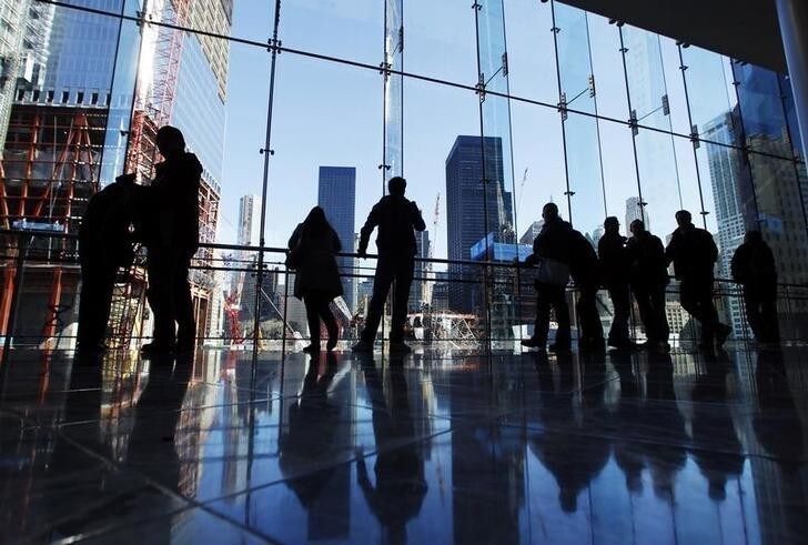 Pedestrians stop to look at the construction site of the World Trade Center through a window in New York March 7, 2011.