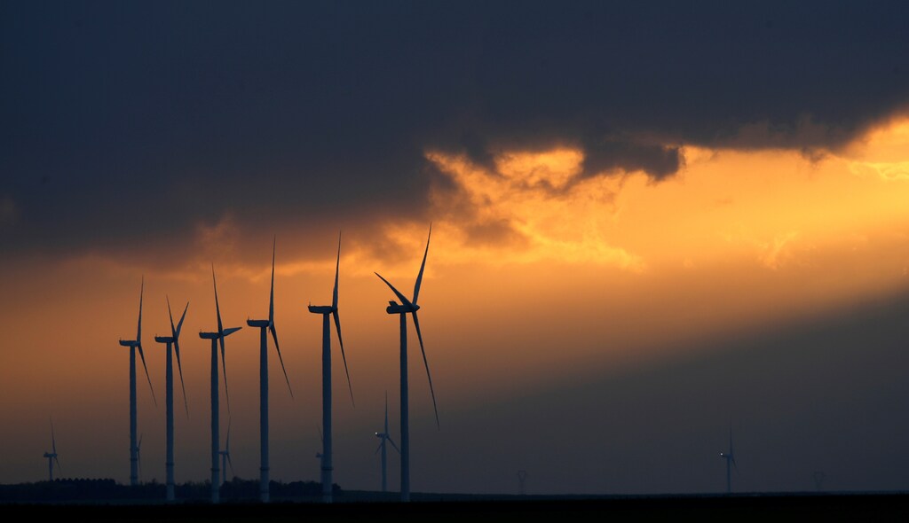Power-generating windmill turbines are seen during sunset at a wind park near Reims, France, November 13, 2017. REUTERS/Christian Hartmann - RC1406F2E060