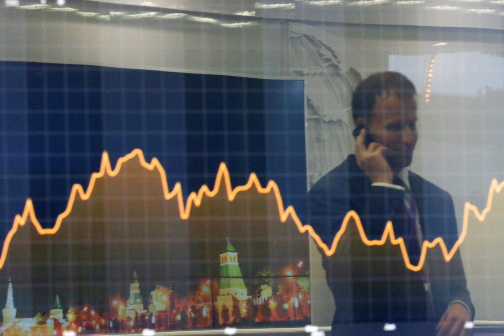 A participant is reflected in a display showing business and financial information at the VTB Capital "Russia Calling!" Investment Forum in Moscow, Russia, October 2, 2014. REUTERS/Maxim Shemetov/File Photo - RTSFODU