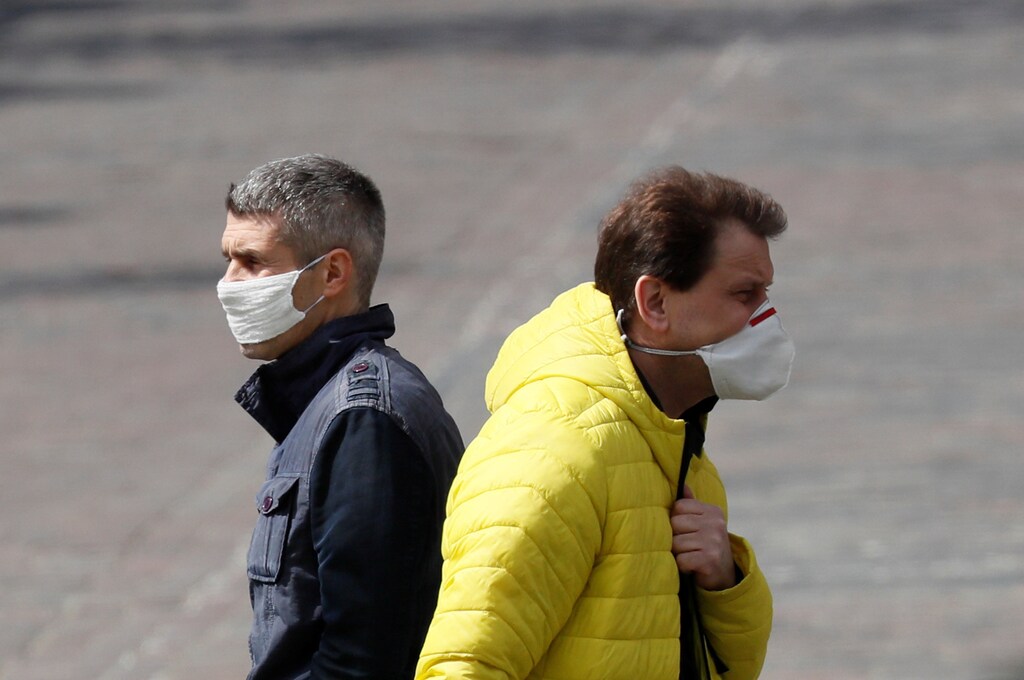 Men wearing protective masks cross a street amid the coronavirus disease (COVID-19) outbreak in Kiev, Ukraine April 21, 2020. REUTERS/Gleb Garanich - RC219G9O6LYN