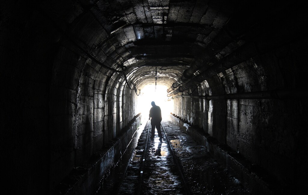 A mine worker is silhouetted as he walks inside a tunnel at the Kilembe mines, in the foothills of the Rwenzori Mountains, 497km (309 miles) west of Uganda's capital Kampala, January 31, 2013. The Kilembe copper-cobalt mine operated from 1956 to 1972, when it closed due to a drop in world copper prices and now lay in ruins. Uganda's President Yoweri Museveni has promised to rehabilitate the Kilembe mines. REUTERS/James Akena (UGANDA - Tags: ENVIRONMENT BUSINESS COMMODITIES EMPLOYMENT) - GM1E92103TH01