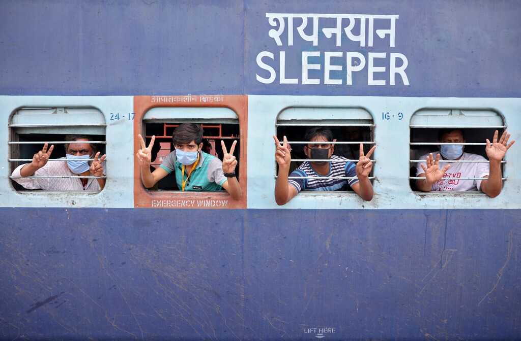 Migrant workers and pilgrims, who were stranded in the western state of Rajasthan due to a lockdown imposed by the government to prevent the spread of coronavirus disease (COVID-19), gesture from inside a train upon their arrival in their home state of eastern West Bengal, at a railway station on the outskirts of Kolkata, India, May 5, 2020. REUTERS/Rupak De Chowdhuri - RC27IG9107UV