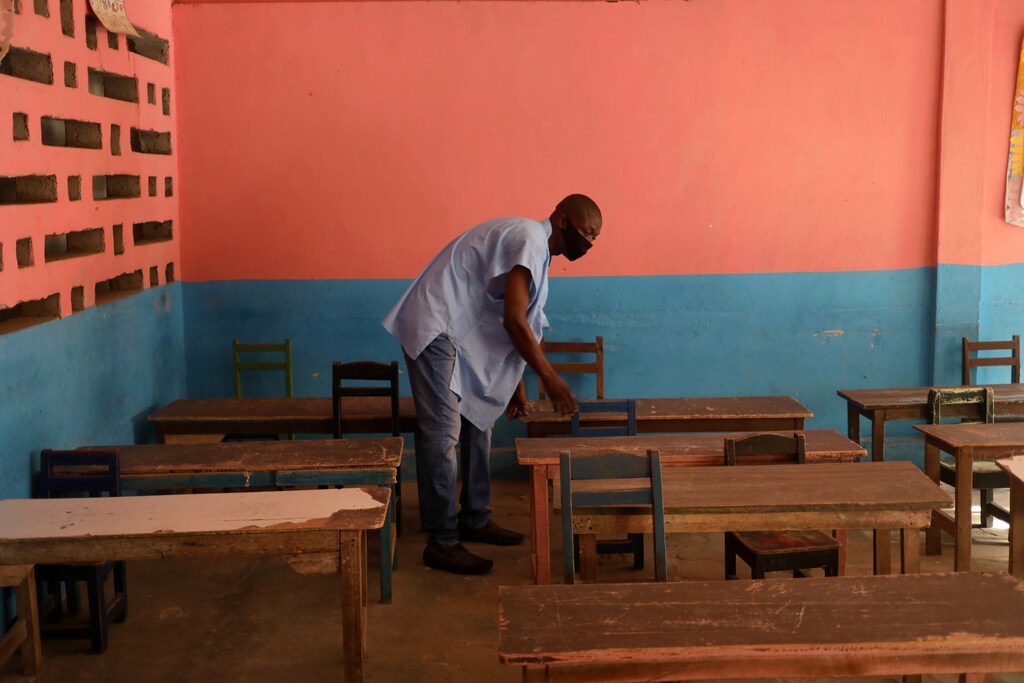 A teacher, wearing a protective mask, works in an empty classroom to maintain social distancing at the Merlan school of Paillet during the reopening of schools, as the lockdown due to coronavirus disease (COVID-19) is eased, in Abidjan, Ivory Coast May 25, 2020. REUTERS/Luc Gnago - RC2OVG9AHG9S