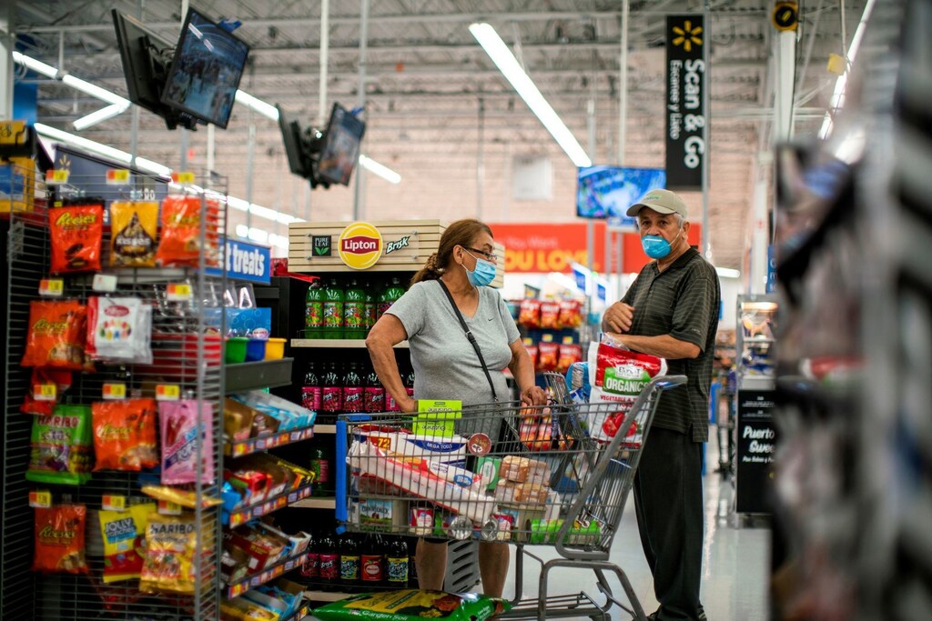 Top economics stories this week: Shoppers are seen wearing masks while shopping at a Walmart store in the US.