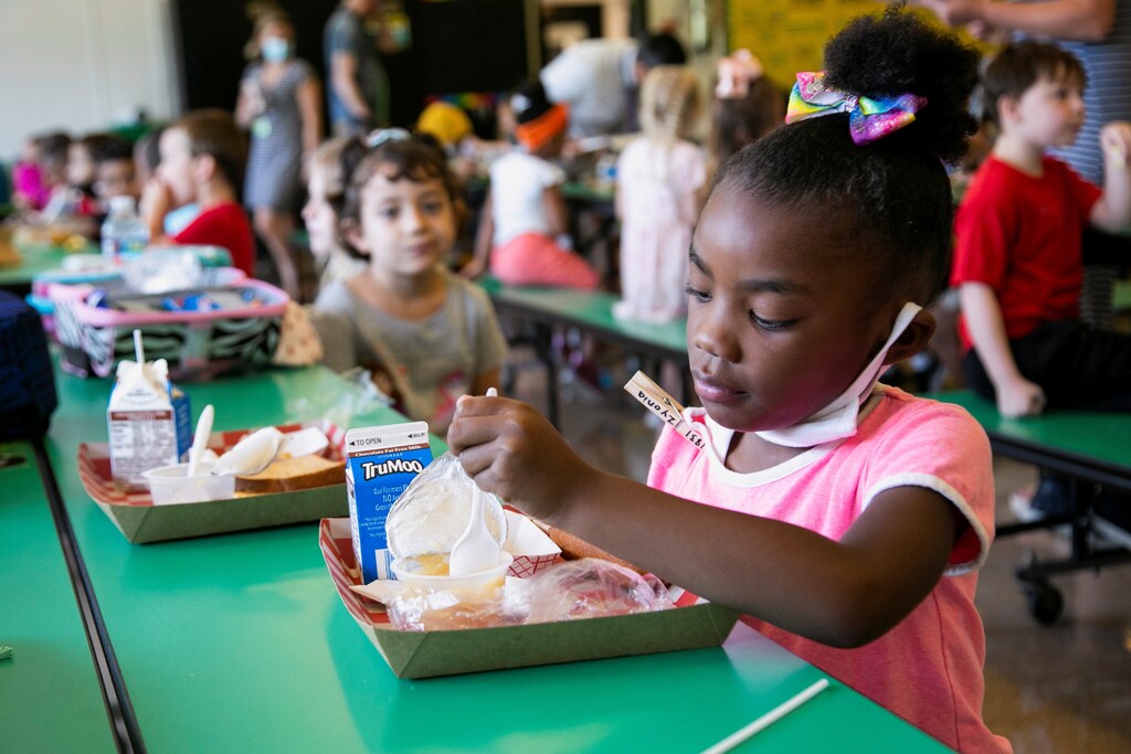 A student takes away her mask as she eats lunch at Wilder Elementary School in Louisville, KY, Kentucky.