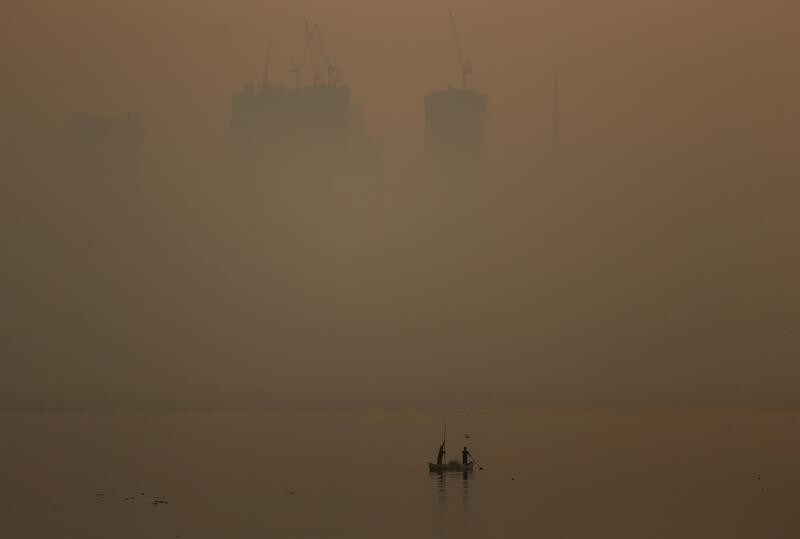 Men row a boat in the waters of the Arabian Sea on a smoggy evening in Mumbai, India, January 18, 2019. REUTERS/Francis Mascarenhas - RC1492BC28C0