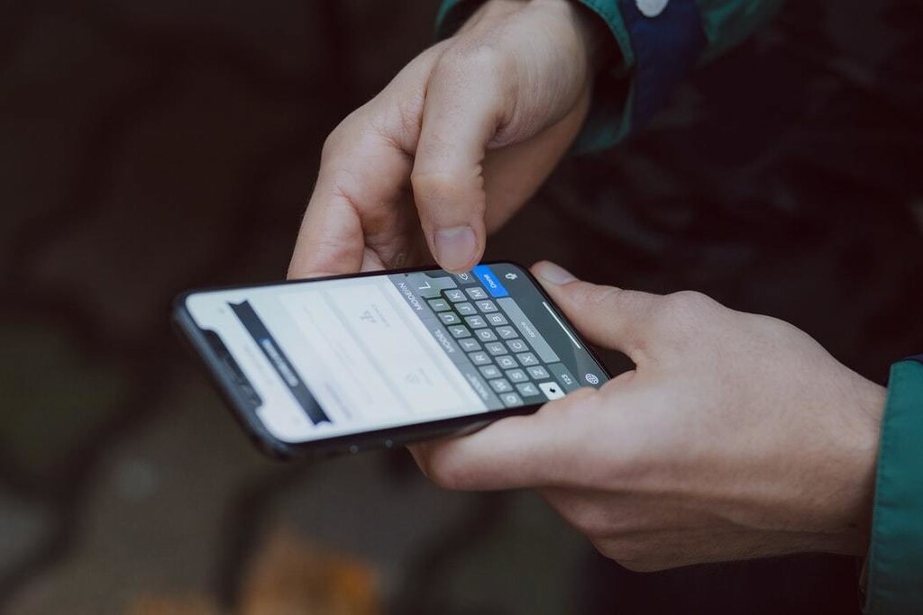 Person typing on smartphone.