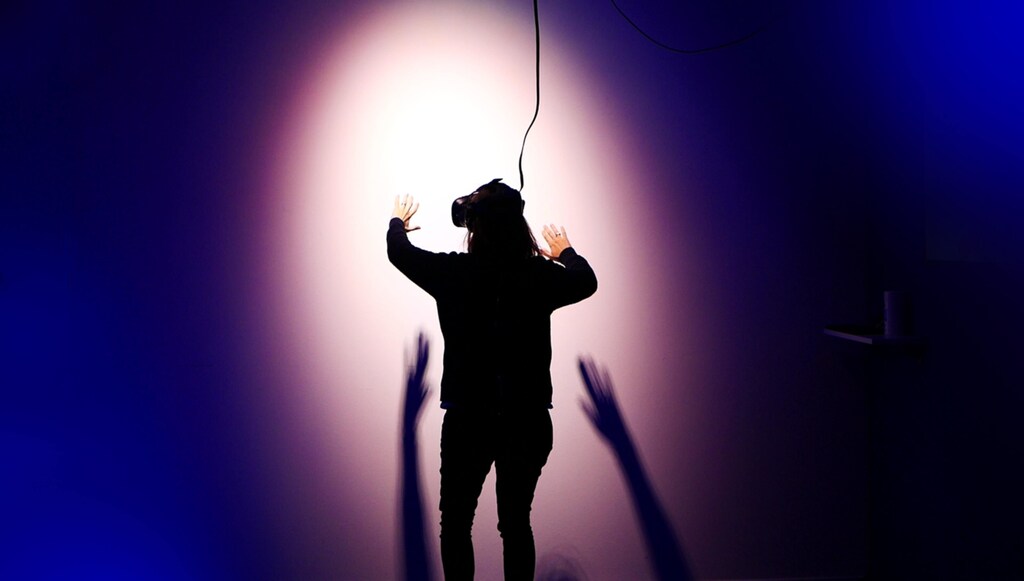 Metaverse: A woman wearing a VR headset facing a blank wall.