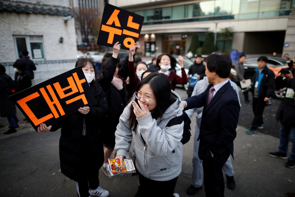 High school students cheer on a senior schoolmate (C) before she takes the annual college entrance examinations, in front of an exam hall in Seoul, South Korea, November 15, 2018. REUTERS/Kim Hong-Ji - RC19B9097410
