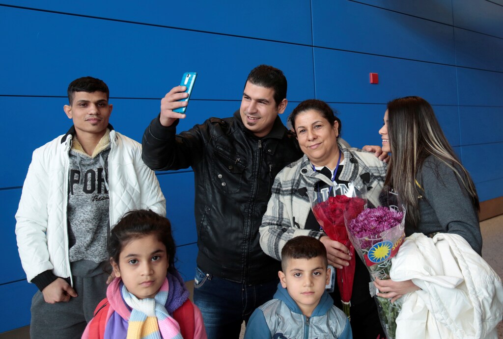 Iraqi refugee Amira Al-Qassab (2nd R) and four of her children are reunited with her son Rami as he uses his phone to Facetime the event to a relative as they arrive at Detroit Metro Airport in Romulus, Michigan, U.S. February 10, 2017. REUTERS/Rebecca Cook TPX IMAGES OF THE DAY - RC182F7122E0