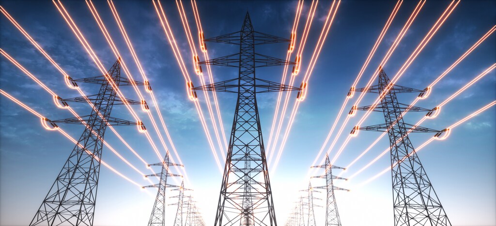 High voltage transmission towers with red glowing wires against blue sky - Energy transition