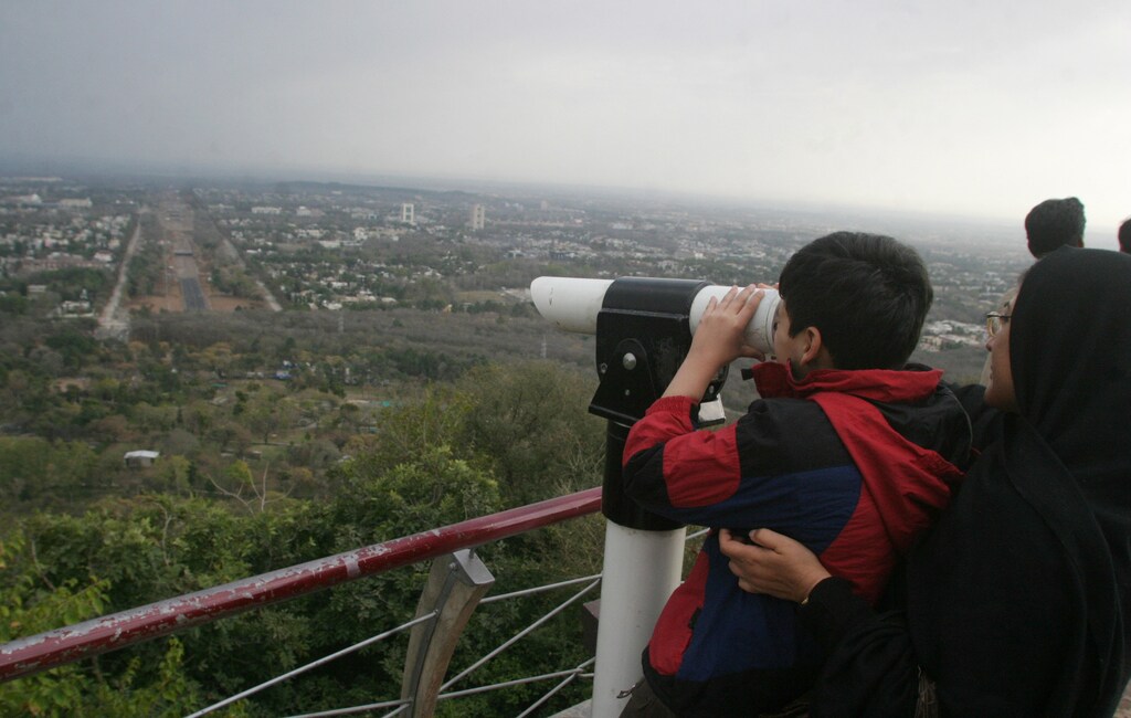 A boy looks out over the leafy Pakistani capital from a hillside viewing point in Islamabad March 4, 2007