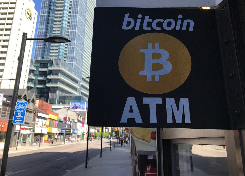 A sign is seen outside a business where a Bitcoin ATM is located in Toronto, Ontario, Canada June 3, 2017. REUTERS/Chris Helgren - RTX38TWD