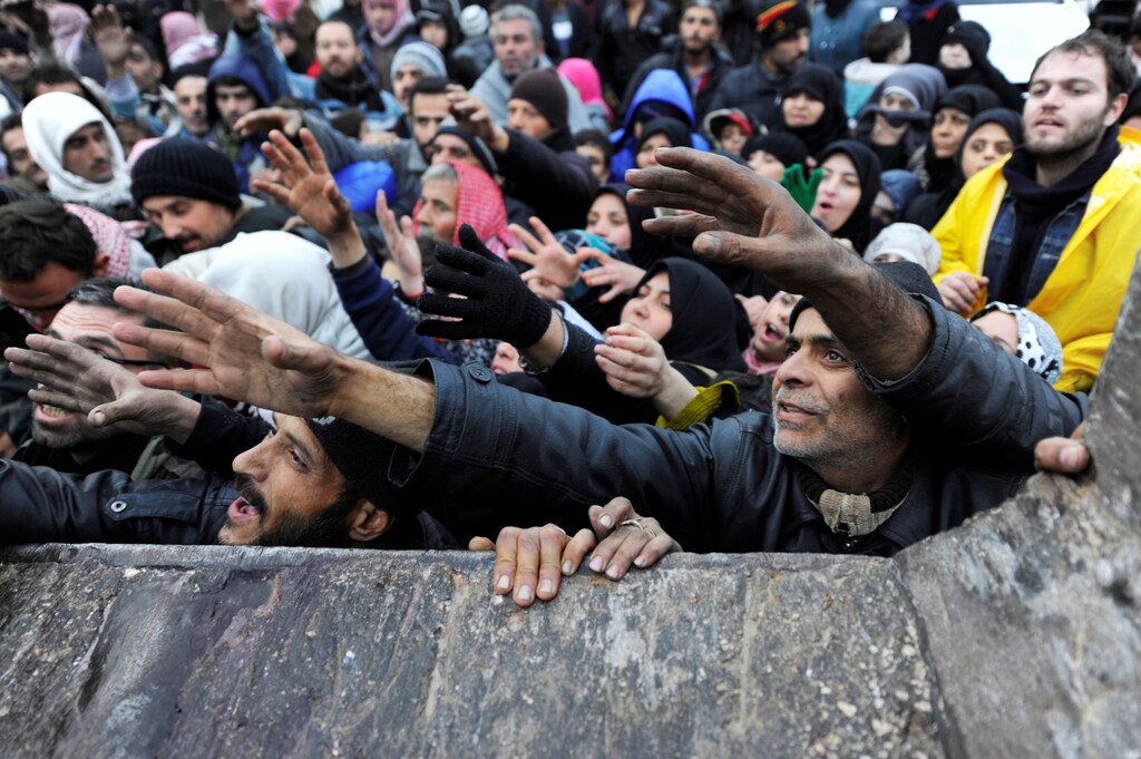 Syrians evacuated from eastern Aleppo, reach out for Russian food aid in government controlled Jibreen area in Aleppo, Syria November 30, 2016. REUTERS/Omar Sanadiki - RTSU1OG
