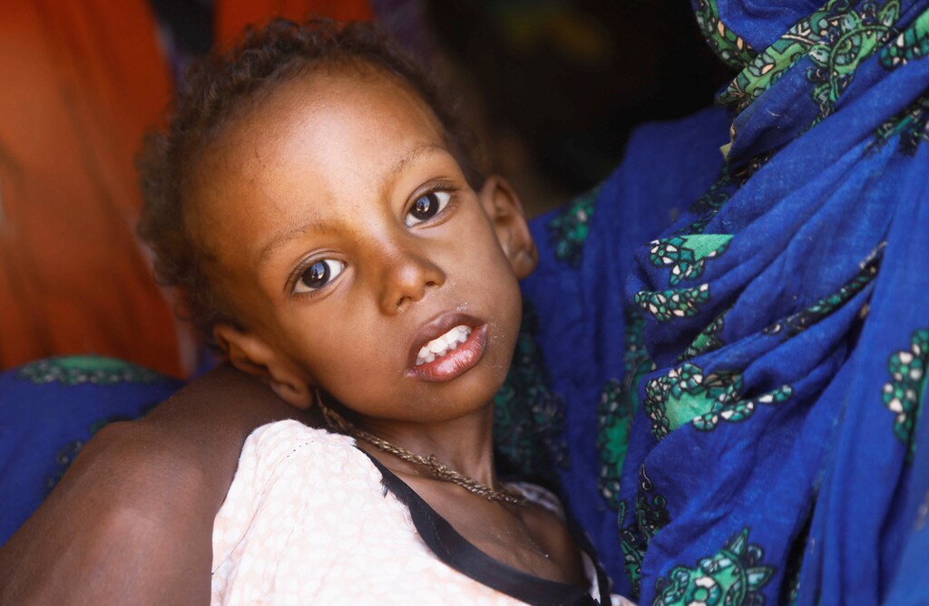 A Somali woman carries a child.