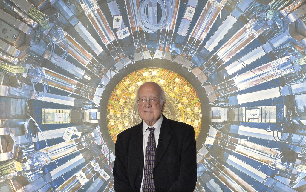Peter Higgs poses in front of a photographic image of the Atlas detector at the Science Museum, London.