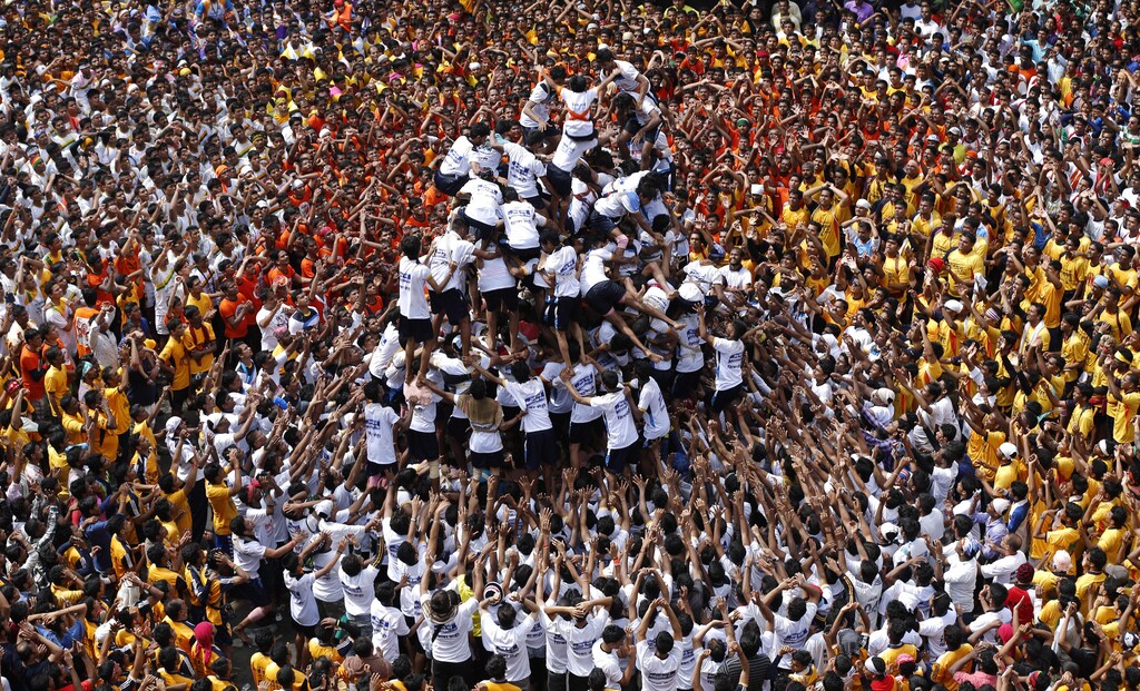 Devotees try to form a human pyramid to break a clay pot containing curd during the celebrations to mark the Hindu festival of Janmashtami in Mumbai August 18, 2014. Janmashtami, which marks the birthday of Hindu god Krishna, is being celebrated across the country today. REUTERS/Shailesh Andrade (INDIA - Tags: RELIGION TPX IMAGES OF THE DAY) FOR BEST QUALITY IMAGE ALSO SEE: GF2EAAD0ALF01 - GM1EA8I1UMN01