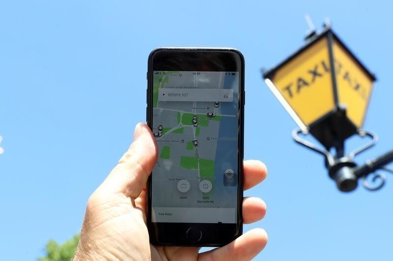 A photo illustration shows the Uber app and a taxi sign in London, Britain June 26, 2018.
