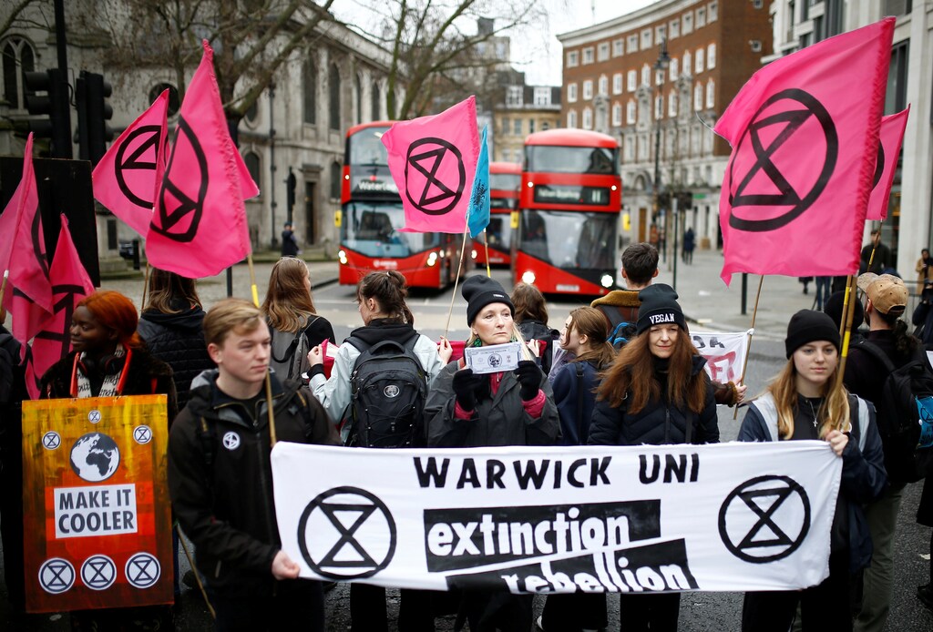 Extinction Rebellion activists block a road, holding banners and flags, during protest outside a venue for London Fashion Week, Britain February 15, 2020. REUTERS/Henry Nicholls - RC2Y0F9K07FN