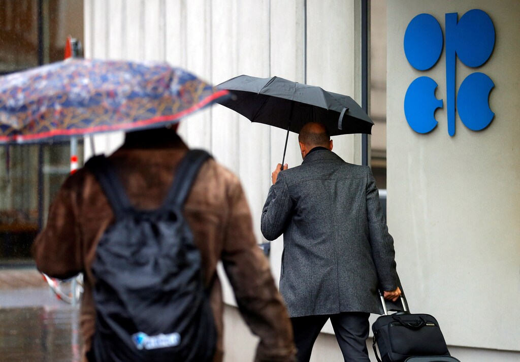 People carrying umbrellas walk by the Ogranization of the Petroleum Exporting Countries (OPEC) headquarters in Vienna, Austria October 4, 2016. REUTERS/Heinz-Peter Bader - RTSQO1U