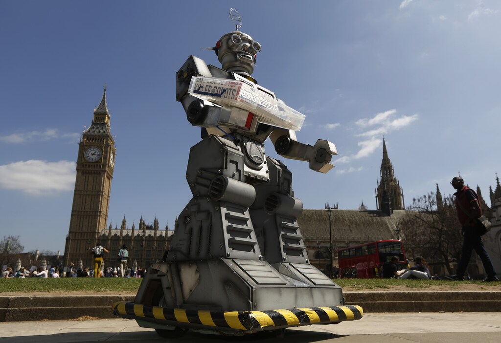 A robot is pictured in front of the Houses of Parliament and Westminster Abbey as part of the Campaign to Stop Killer Robots in London April 23, 2013. Robots with the ability to attack targets without any human intervention must be banned before they are even developed for use in a battlefield, campaigners urged on Tuesday. REUTERS/Luke MacGregor (BRITAIN - Tags: SCIENCE TECHNOLOGY MILITARY CONFLICT POLITICS CIVIL UNREST) - LM1E94N172P01